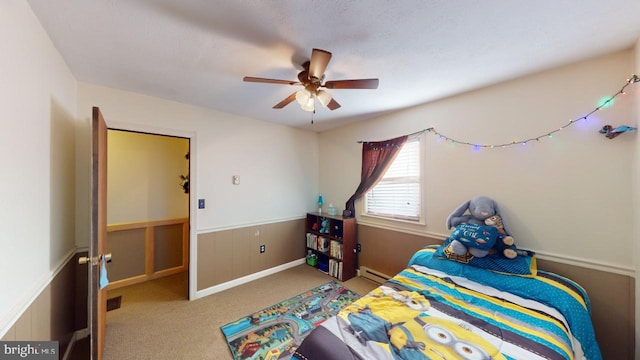 carpeted bedroom with ceiling fan and a baseboard heating unit