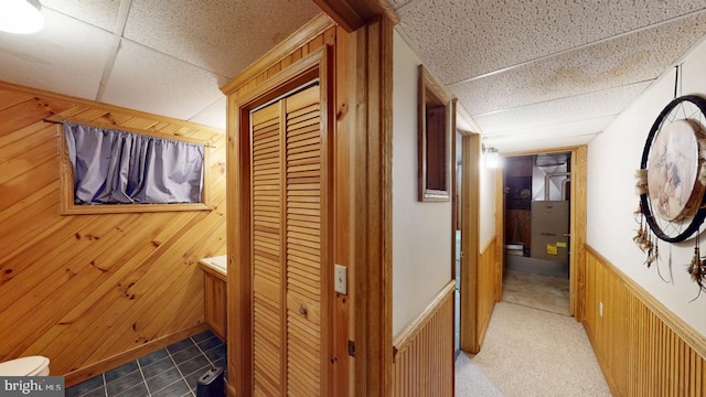 hall with dark carpet and wood walls