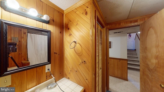 interior space with a textured ceiling and wooden walls