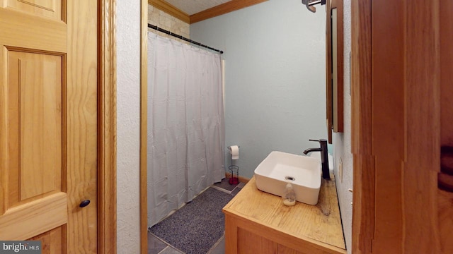 bathroom with ornamental molding and sink