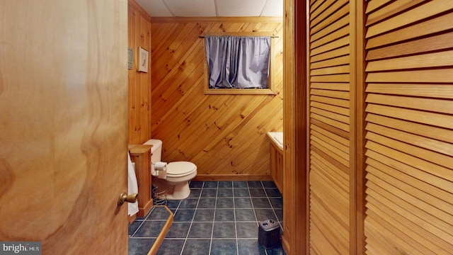 bathroom featuring toilet and wooden walls