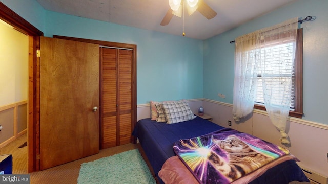 carpeted bedroom with ceiling fan and a closet