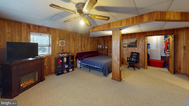 bedroom featuring carpet flooring, ceiling fan, and wooden walls