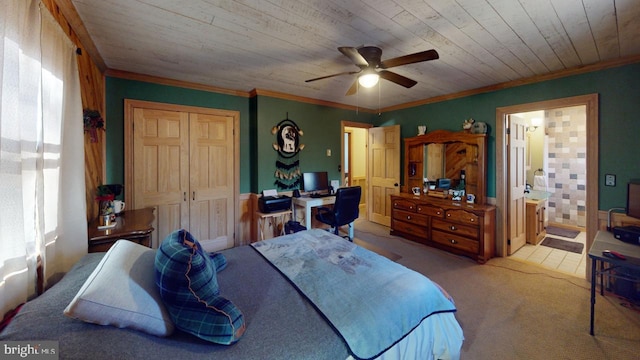 carpeted bedroom featuring ensuite bathroom, ceiling fan, crown molding, wooden ceiling, and a closet