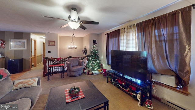 carpeted living room with baseboard heating and ceiling fan with notable chandelier