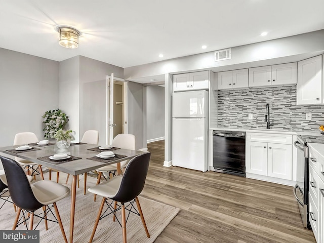 dining space with hardwood / wood-style flooring and sink