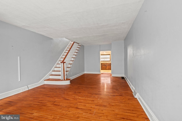 unfurnished living room featuring a textured ceiling and hardwood / wood-style flooring