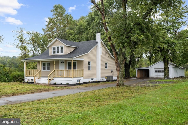 view of front of house featuring a front yard, a porch, central AC unit, a garage, and an outdoor structure