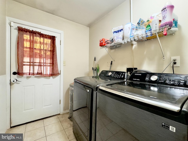 laundry room featuring washing machine and dryer and light tile patterned floors