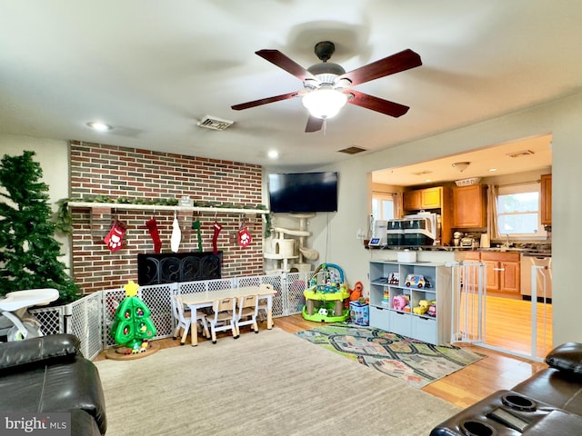 living room featuring ceiling fan and light hardwood / wood-style flooring