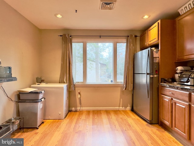 kitchen featuring light hardwood / wood-style flooring, stainless steel refrigerator, and fridge