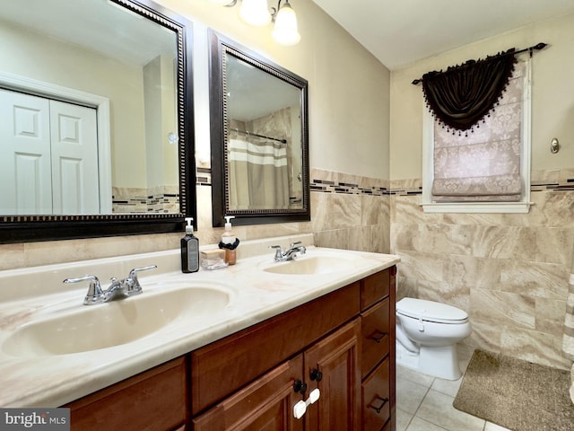 bathroom featuring tile patterned flooring, vanity, toilet, and tile walls