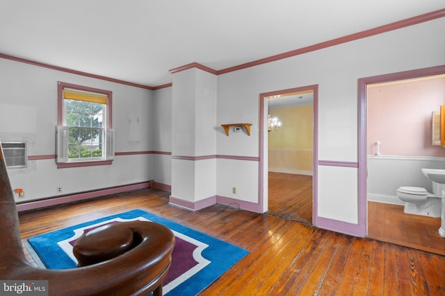 unfurnished room with dark hardwood / wood-style floors, crown molding, a baseboard heating unit, and a notable chandelier