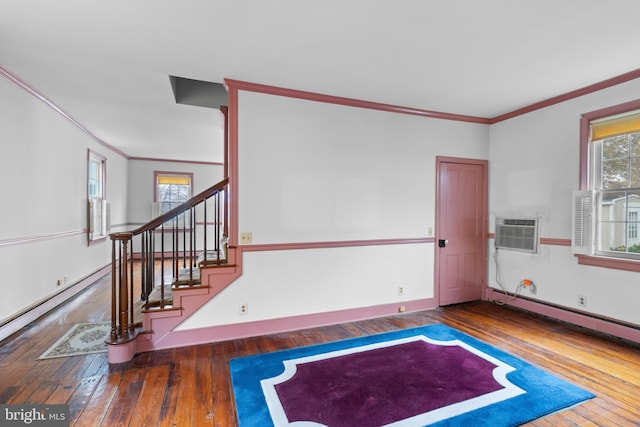 interior space with a wall mounted air conditioner, a baseboard heating unit, dark hardwood / wood-style flooring, and crown molding