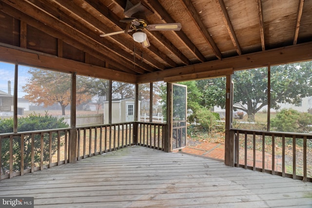 deck featuring ceiling fan and a shed