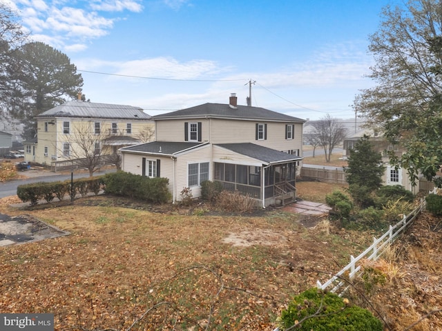 rear view of house featuring a sunroom