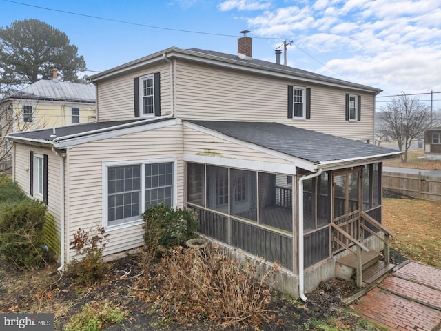 rear view of house featuring a sunroom