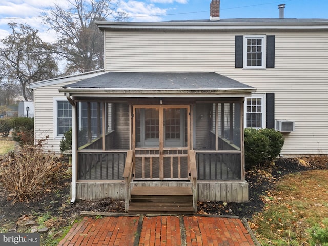 rear view of house featuring a sunroom