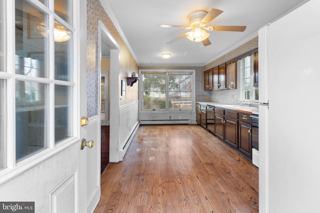 interior space featuring light hardwood / wood-style flooring, baseboard heating, ornamental molding, and sink