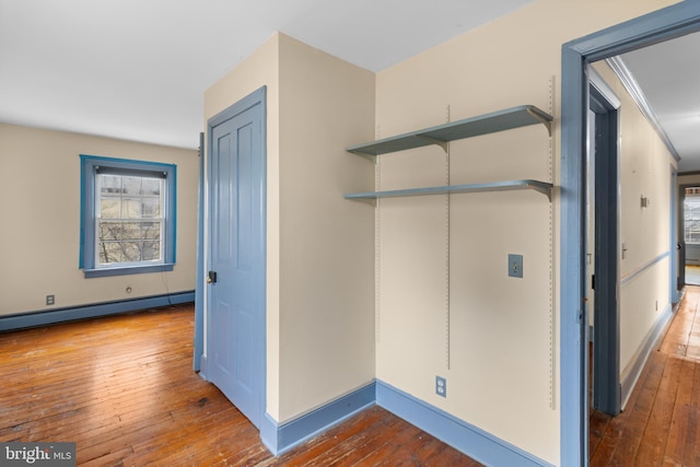 washroom with crown molding, wood-type flooring, and baseboard heating