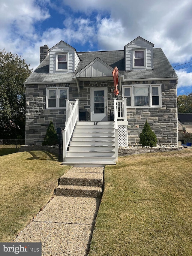 cape cod home with a front lawn