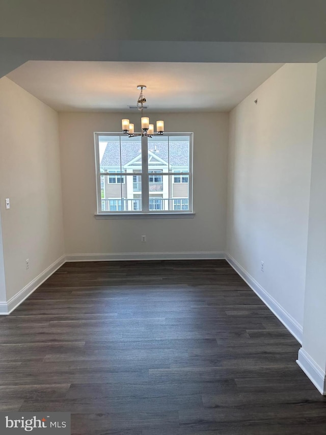 unfurnished dining area featuring dark hardwood / wood-style floors and an inviting chandelier