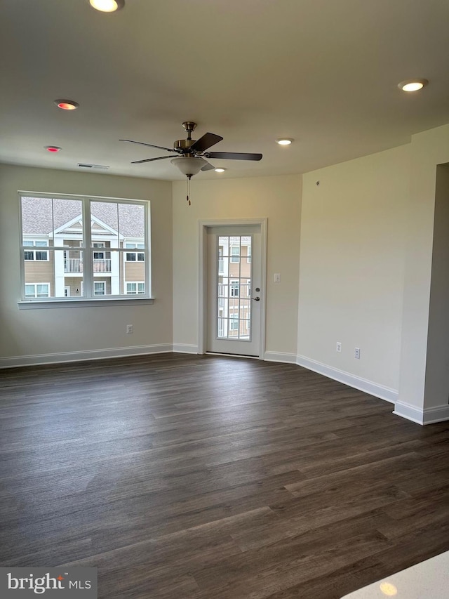 unfurnished room featuring ceiling fan, plenty of natural light, and dark hardwood / wood-style floors