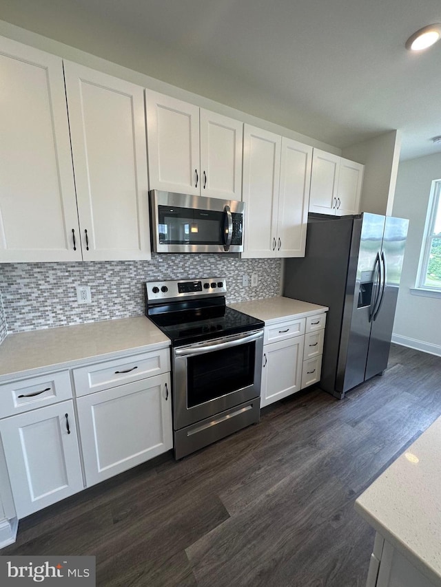 kitchen featuring white cabinets, dark hardwood / wood-style flooring, stainless steel appliances, and tasteful backsplash