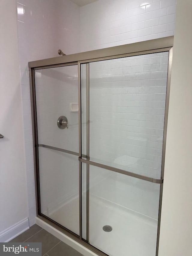 bathroom with tile patterned flooring and a shower with door