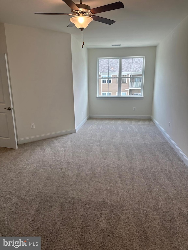 carpeted spare room with ceiling fan