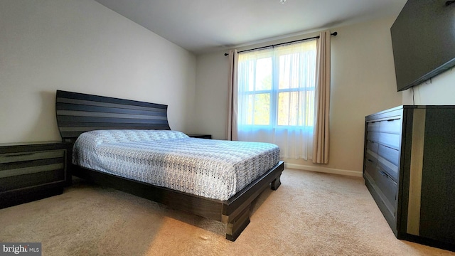 bedroom featuring light carpet and lofted ceiling