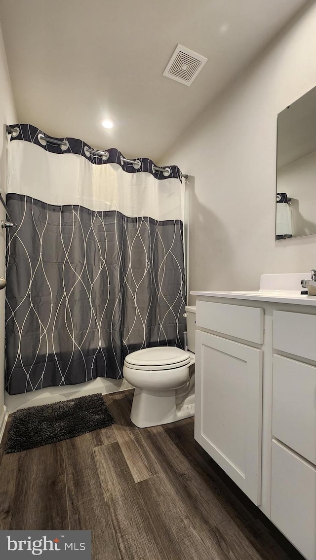 bathroom featuring wood-type flooring, vanity, and toilet