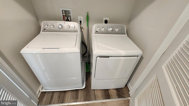 laundry area with hardwood / wood-style flooring and washer and dryer