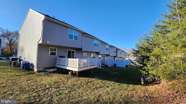 rear view of property with a yard and a deck