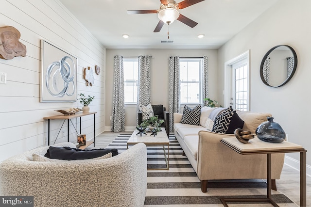 living room with plenty of natural light, ceiling fan, and light wood-type flooring