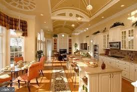 kitchen with crown molding, pendant lighting, vaulted ceiling, and white cabinets