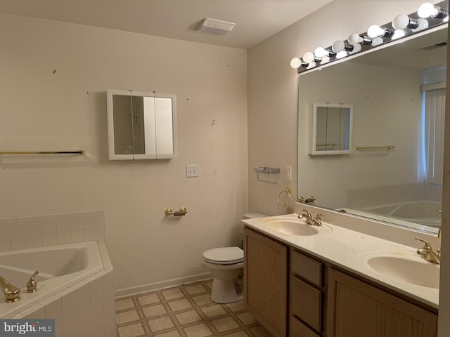 bathroom with vanity, a relaxing tiled tub, and toilet