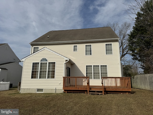 rear view of property with a lawn and a wooden deck