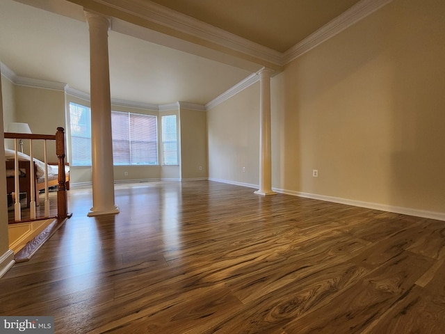 spare room featuring ornamental molding, ornate columns, and dark wood-type flooring