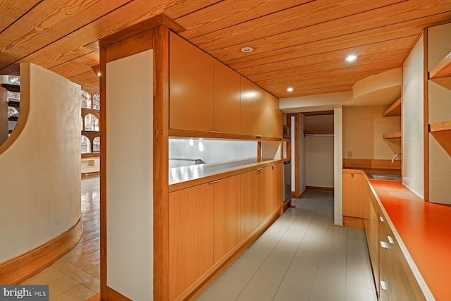 kitchen with light wood-type flooring, wooden ceiling, and sink