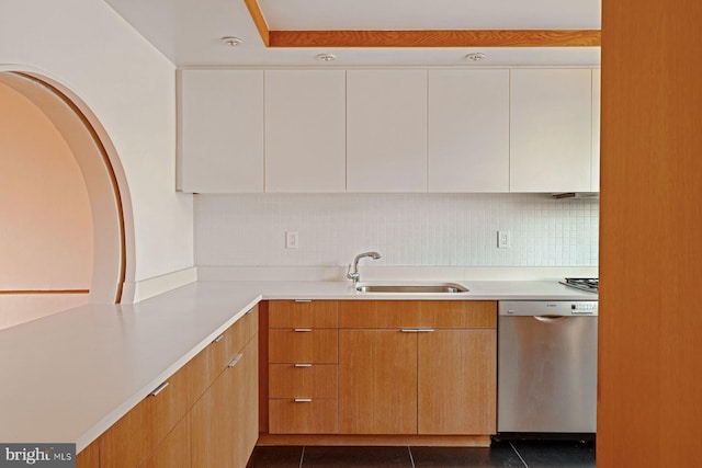 kitchen with stainless steel dishwasher, decorative backsplash, white cabinetry, and dark tile patterned flooring