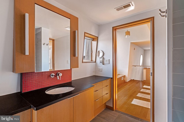 bathroom featuring tasteful backsplash, vanity, and hardwood / wood-style flooring