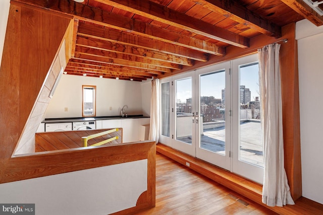 kitchen with wooden ceiling, french doors, beam ceiling, light hardwood / wood-style floors, and washer / clothes dryer