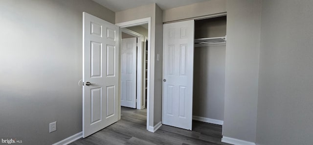 unfurnished bedroom with a closet and dark hardwood / wood-style floors