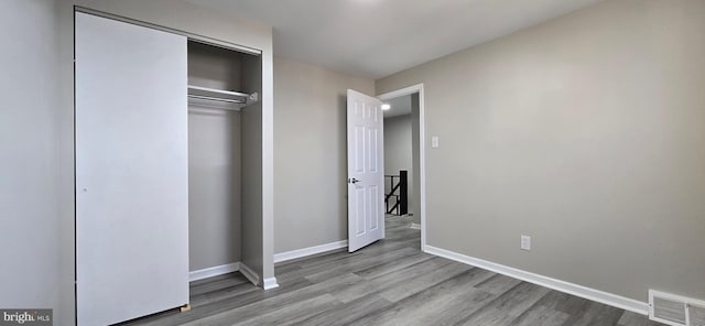 unfurnished bedroom with light wood-type flooring and a closet