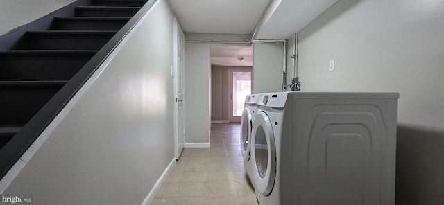 clothes washing area with washing machine and dryer and light tile patterned floors