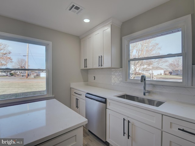 kitchen with white cabinets, dishwasher, backsplash, and sink