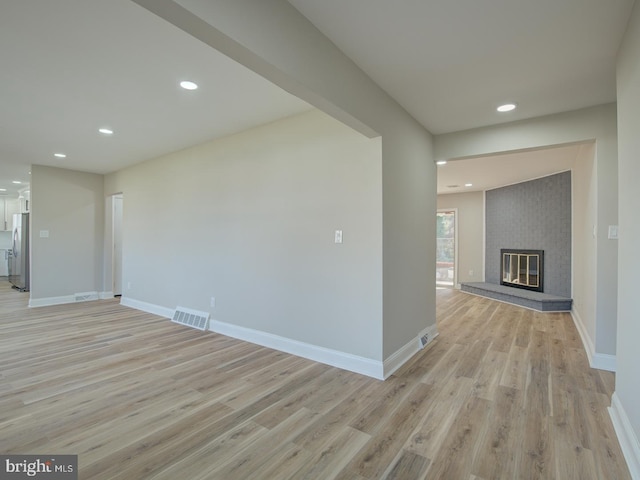 interior space featuring light hardwood / wood-style floors and a brick fireplace