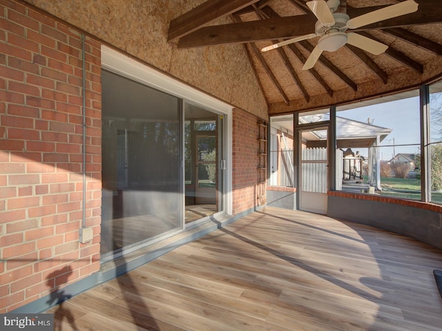 unfurnished sunroom featuring plenty of natural light, lofted ceiling with beams, and ceiling fan