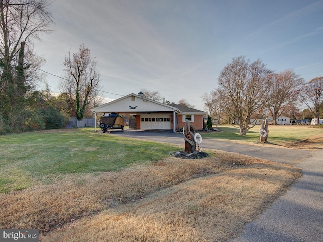 single story home featuring a carport, a garage, and a front lawn